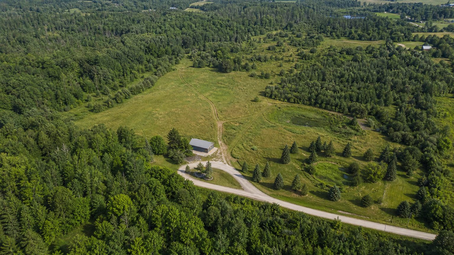 Aerial view of rural land, access road, and site features